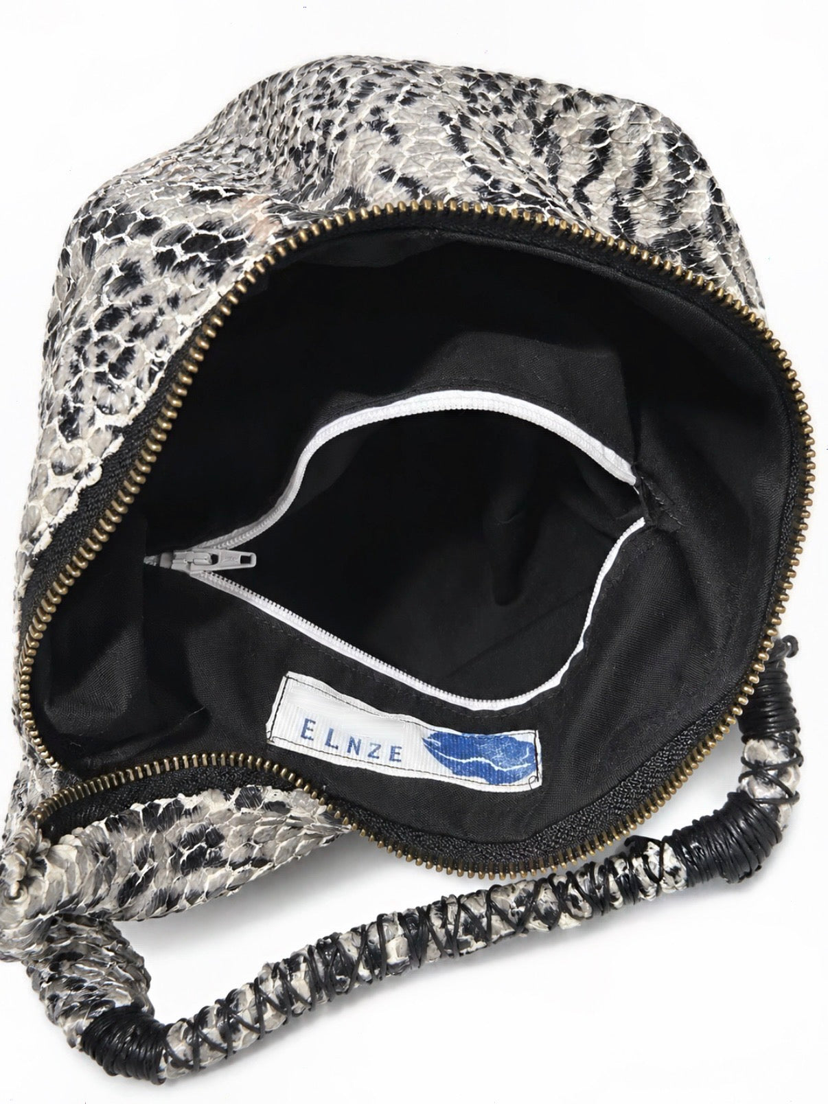 An open handbag with a black and white animal print exterior, a black interior lining, and a visible ELNZE brand label inside. The bag is photographed on a plain white background.